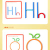 A set of wooden stick and ring puzzles for early learning, showing letters and an apple.