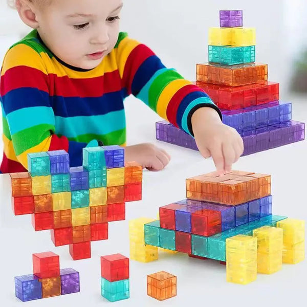 Kind spielt mit bunten, transparenten Magnetbausteinen in verschiedenen Formen und Farben.