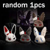 Three gothic bunny plush keychains with bandages and black ears displayed on a dark surface.