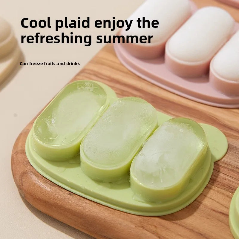 A silicone fruit teether set with green and white fruits is displayed on a wooden cutting board.