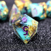A close-up of a translucent teal polyhedral die showing the number 5, set against a dark background with other dice.