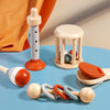 A collection of wooden hand bells and a wooden sensory toy stand on a blue surface.