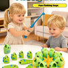 A child is playing a fishing battle game with green and yellow plastic fish on an orange table.