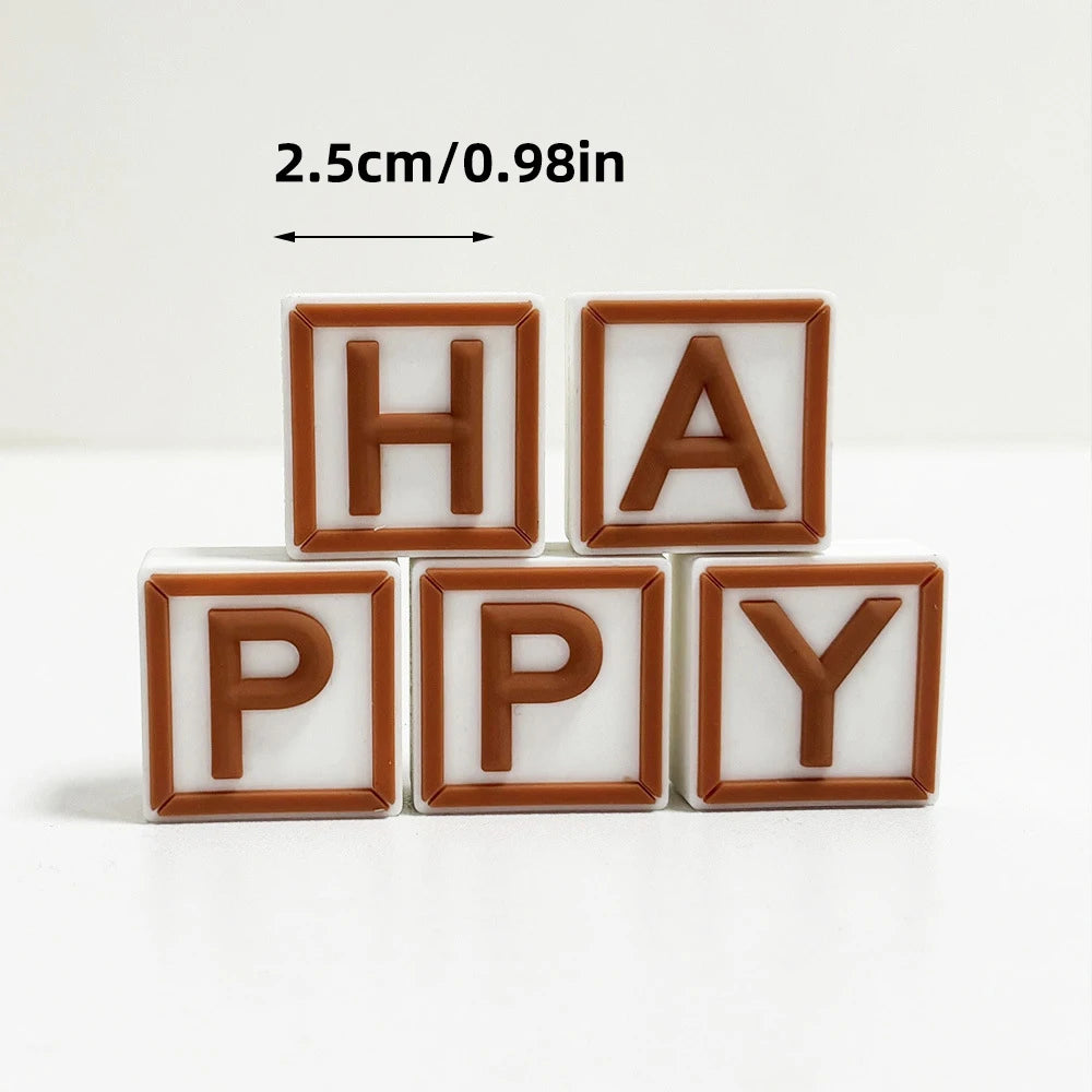 A set of wooden alphabet cake toppers spelling HAPPY with a measurement indicator.