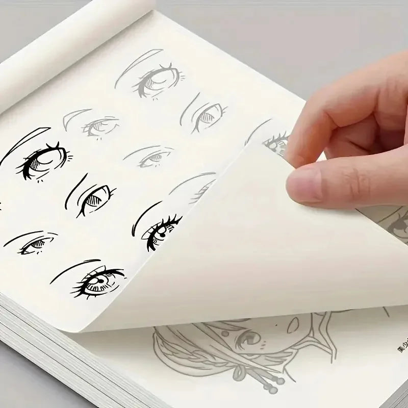 A hand is holding an open drawing book filled with simple line art of various anime-style eyes and faces for tracing practice
