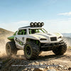 A white and green 1:18 scale RC monster truck driving through dusty, off-road terrain.