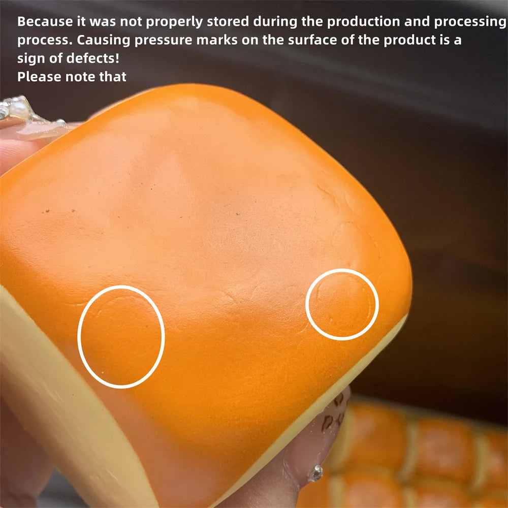 Gros plan d'un pain de mie décoratif orange, doux au toucher, avec deux marques circulaires sur sa surface.