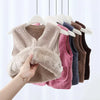 A beige fuzzy lamb wool baby vest is hanging on a white hanger against a light background.