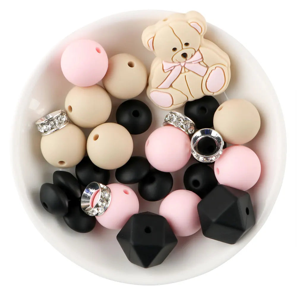 A collection of various colored and textured silicone beads, including pink, beige, and black, for DIY jewelry making.