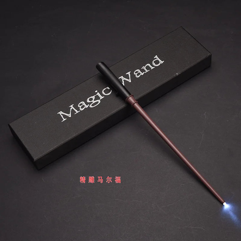 A dark wooden box with 'Magic Wand' inscribed, next to a slender wand with a glowing tip.