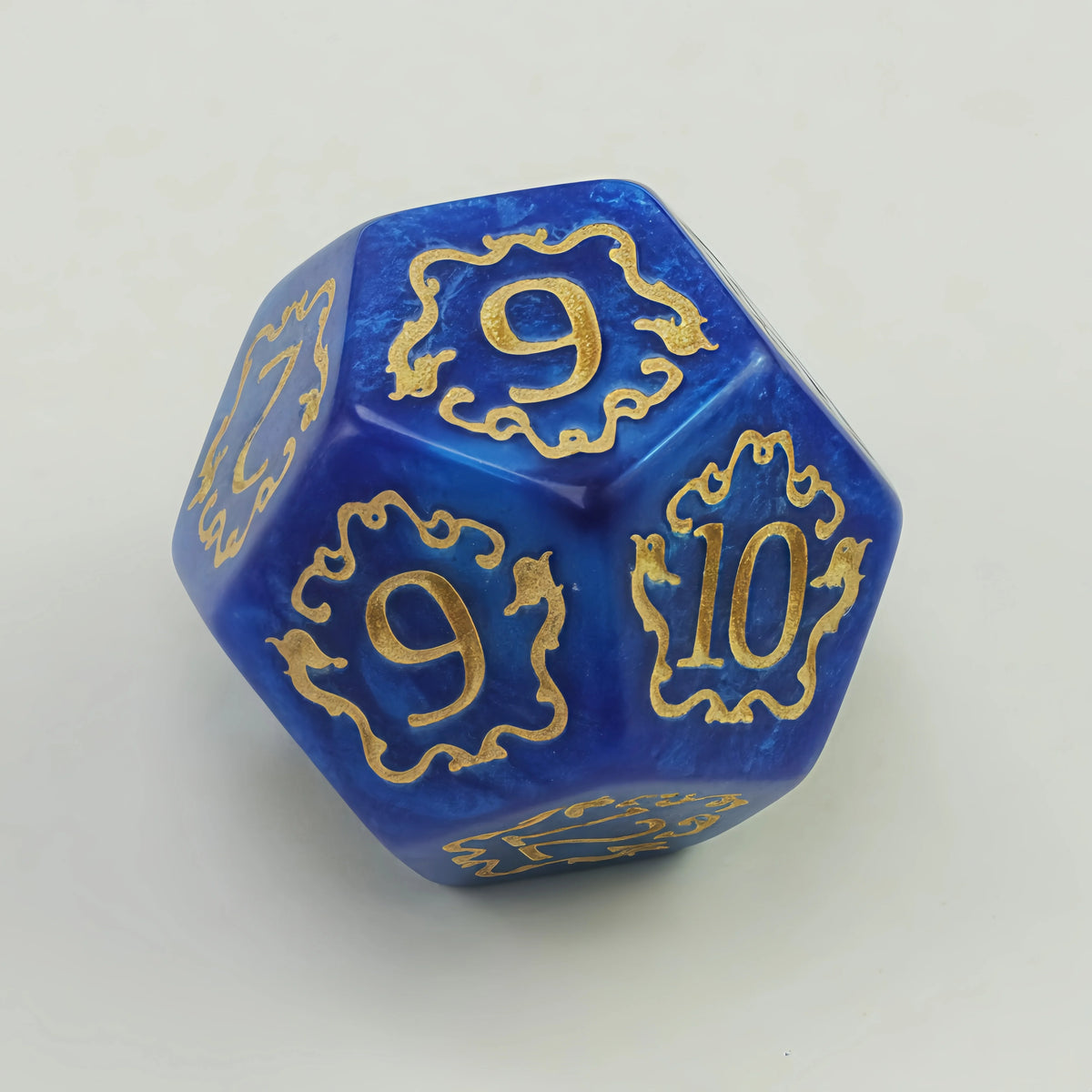 A blue polyhedral die showing the numbers 9 and 10 with gold decorative borders.