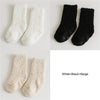 Three pairs of baby anti-slip fleece socks in white, black, and beige.