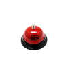 A red metal table bell used for couples' games.