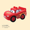 A red die-cast toy car resembling a cartoon character is shown against a light background.