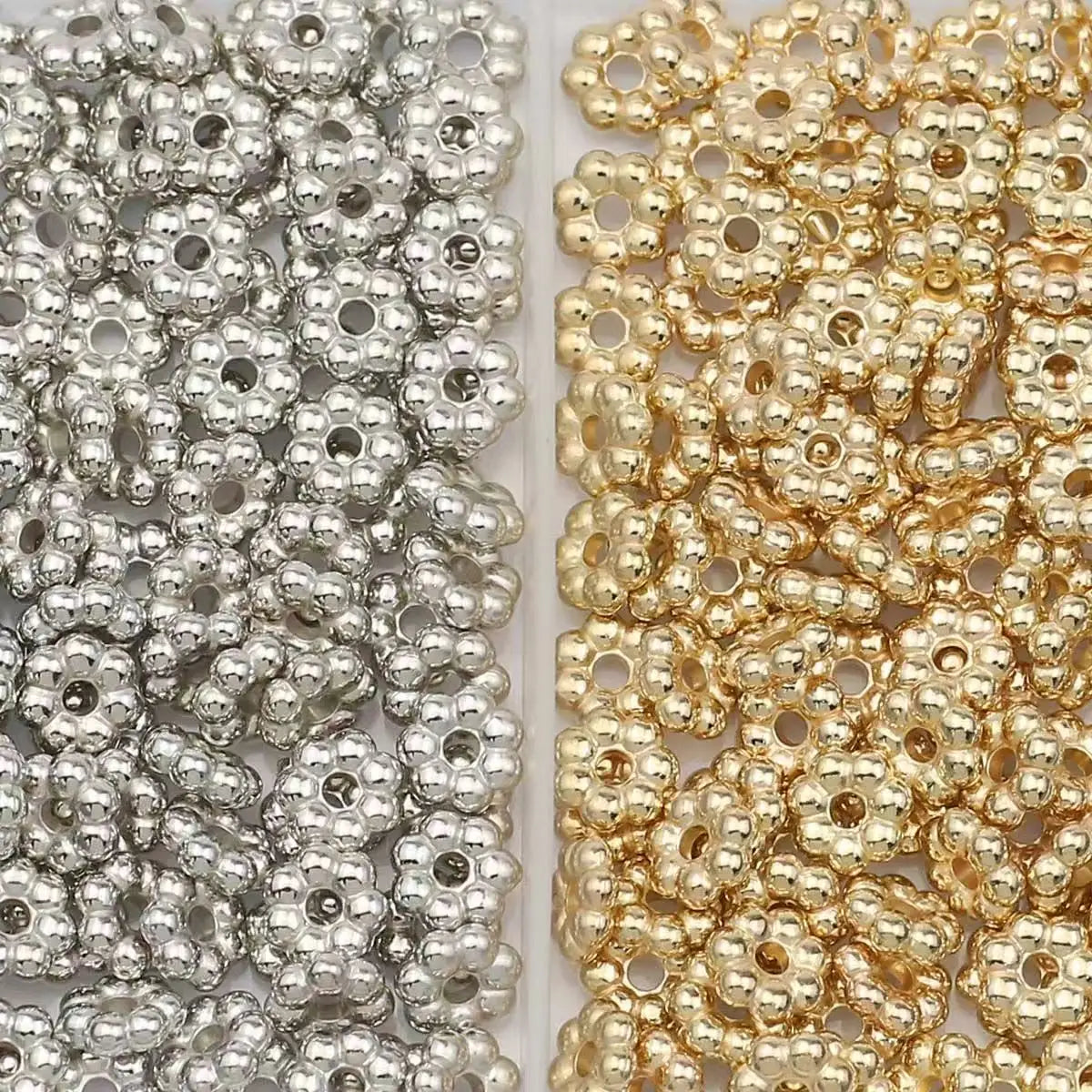A close-up view of a set of 200 snowflake spacer beads for jewelry making, featuring silver and gold colored beads.