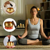 A woman sits in meditation with a handcrafted Tibetan singing bowl on her lap.