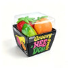 A clear plastic container holds a set of three squishy fruit fidget toys: strawberry, banana, and orange.