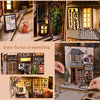 A DIY wooden book nook kit featuring a Japanese alley miniature scene with built-in LED lights and detailed architecture.