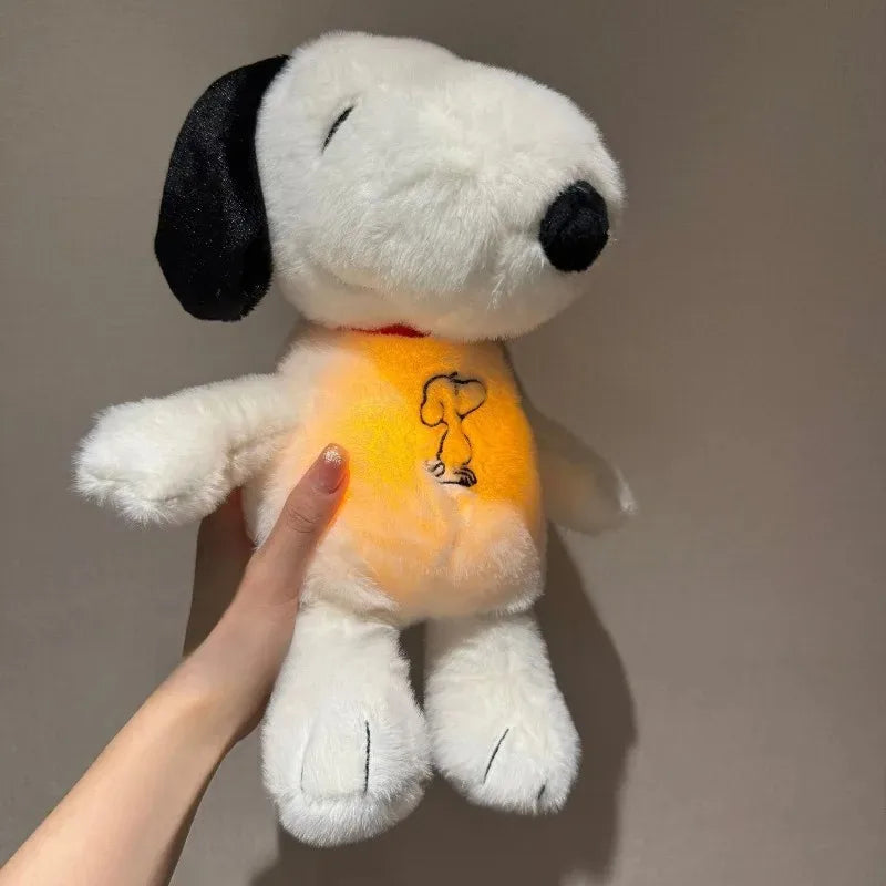 A white plush toy resembling Snoopy with a black ear, being held by a hand.