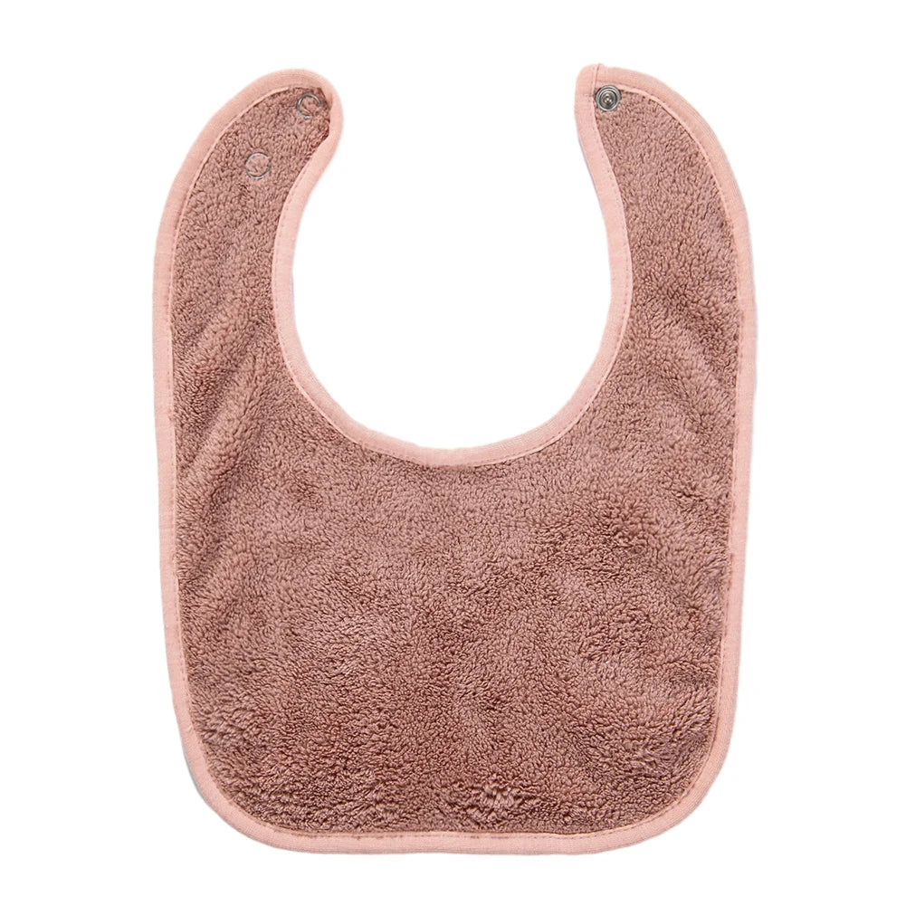 A soft, pink, fuzzy baby bib with an adjustable snap closure.
