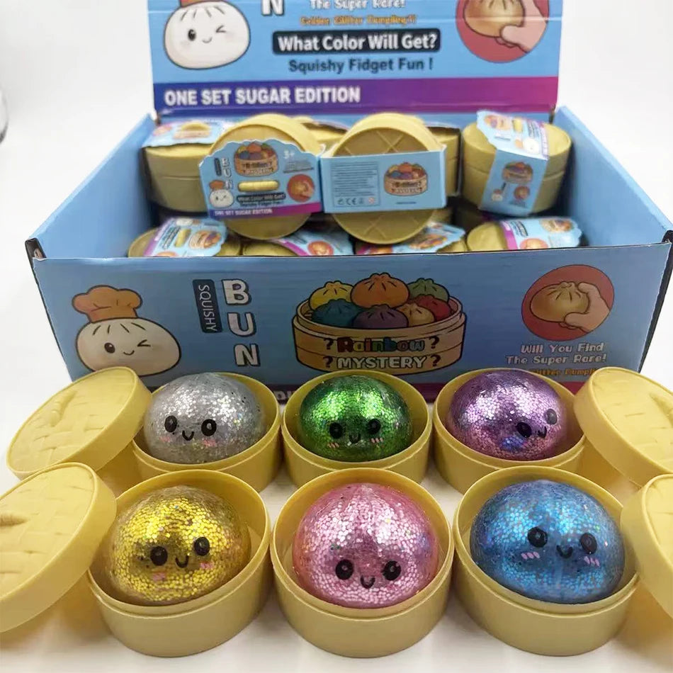 A box of glitter dumpling squishy fidget toys in various colors and shapes.