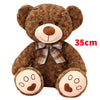 A brown teddy bear plush pillow with a plaid bow and embroidered facial features.