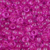 A close-up view of small, translucent pink pony beads for jewelry making and craft projects.