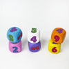 A collection of six colorful dice showing numbers 2, 4, 5, and 6 in various colors like blue, purple, white, and orange.