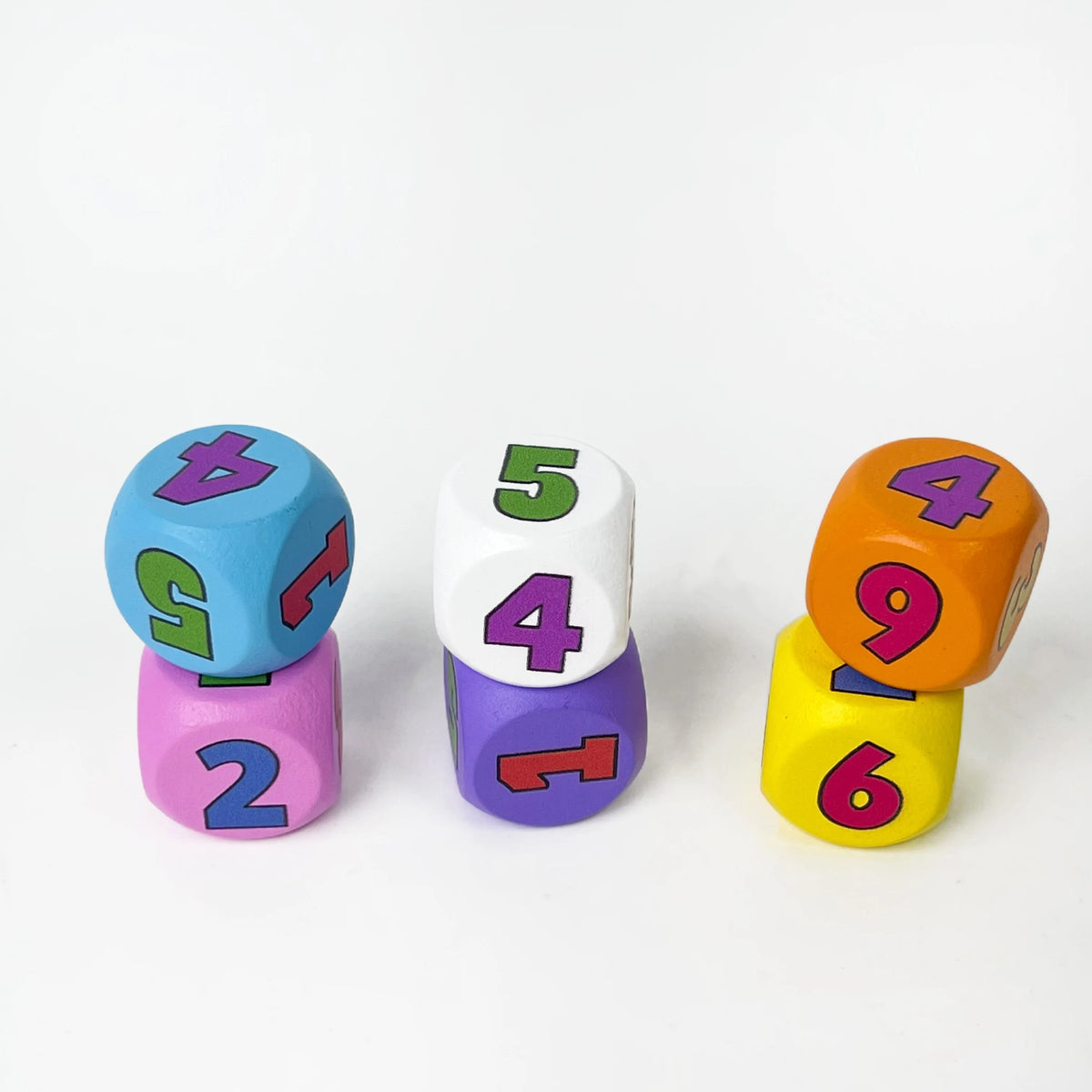 A collection of six colorful dice showing numbers 2, 4, 5, and 6 in various colors like blue, purple, white, and orange.