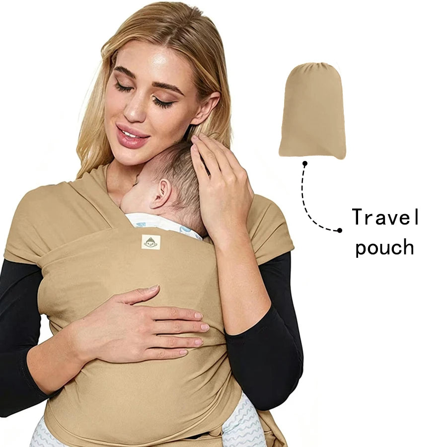 A woman is wearing a beige knitted fabric multi-functional baby carrier with a travel pouch attached.