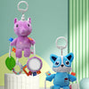 A purple unicorn plush toy with hanging rattles and teething toys displayed on a white surface.