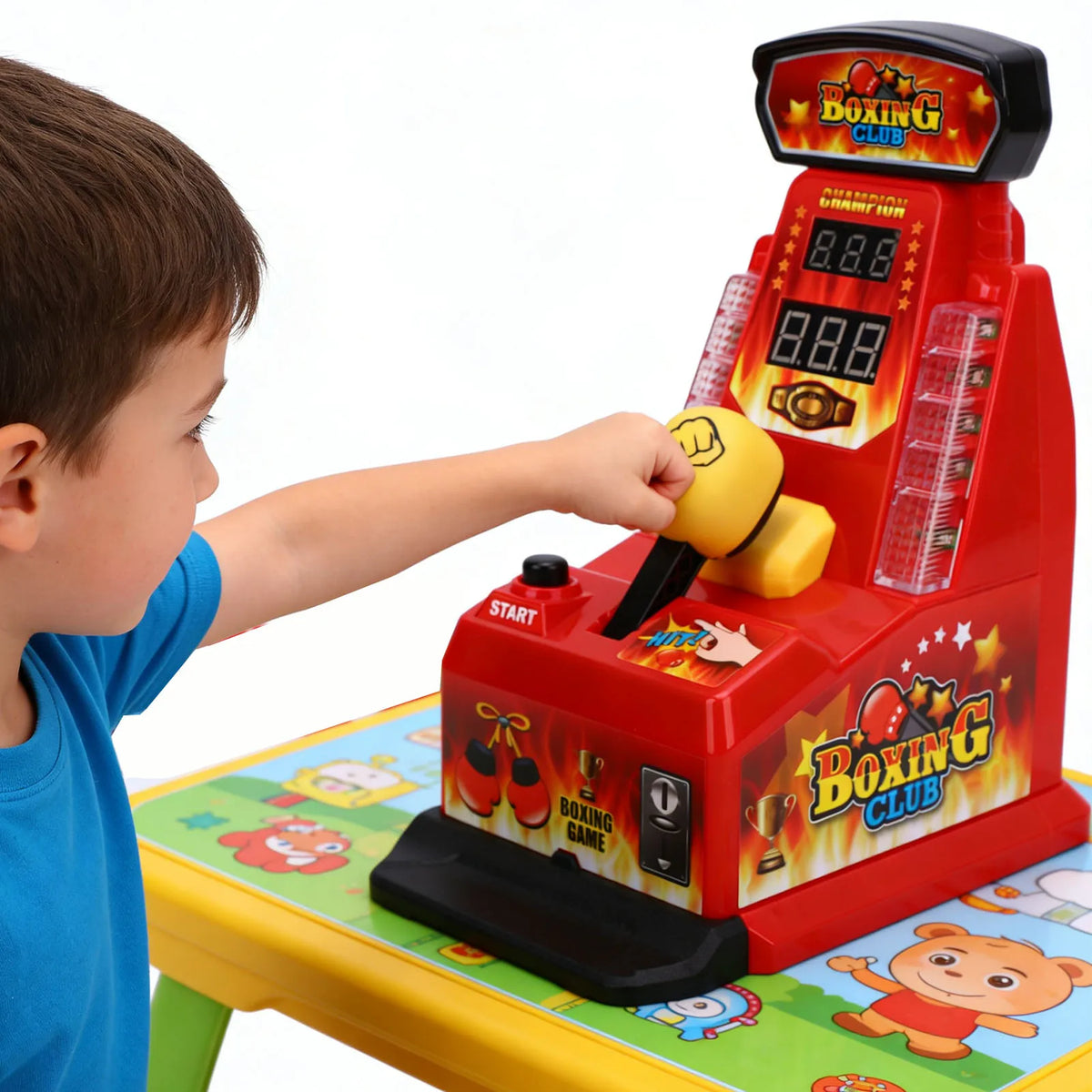A child is playing an interactive finger boxing machine with red and yellow components on a green table.