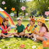 Five children are sitting on the grass surrounded by colorful flower confetti and holding inflatable microphones for a party.