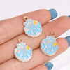 Gold-rimmed blue enamel starfish charms displayed on a hand.