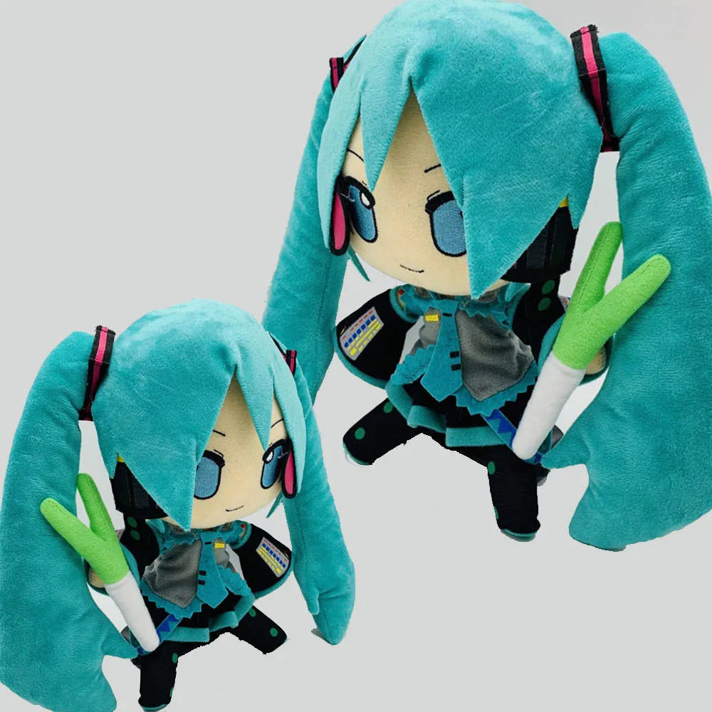 A pair of teal-colored Hatsune Miku plush dolls with long hair and accessories.