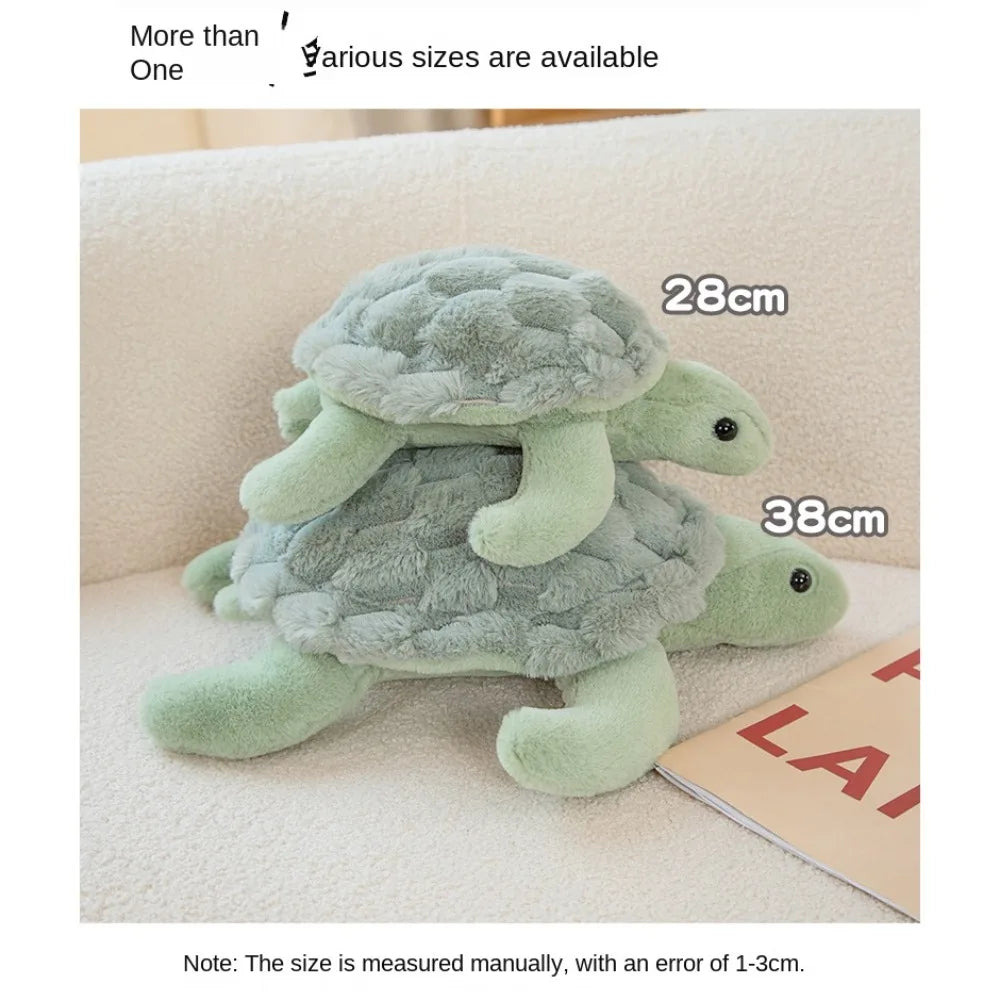 A soft, light green sea turtle plush toy is shown lying on a white surface.