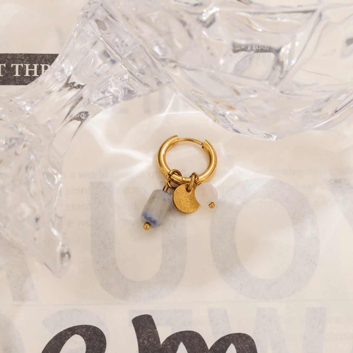 Gold hoop earrings featuring a blue stone and a gold crescent moon charm