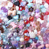 A close-up of colorful acrylic bow beads and various gemstone beads for DIY jewelry making