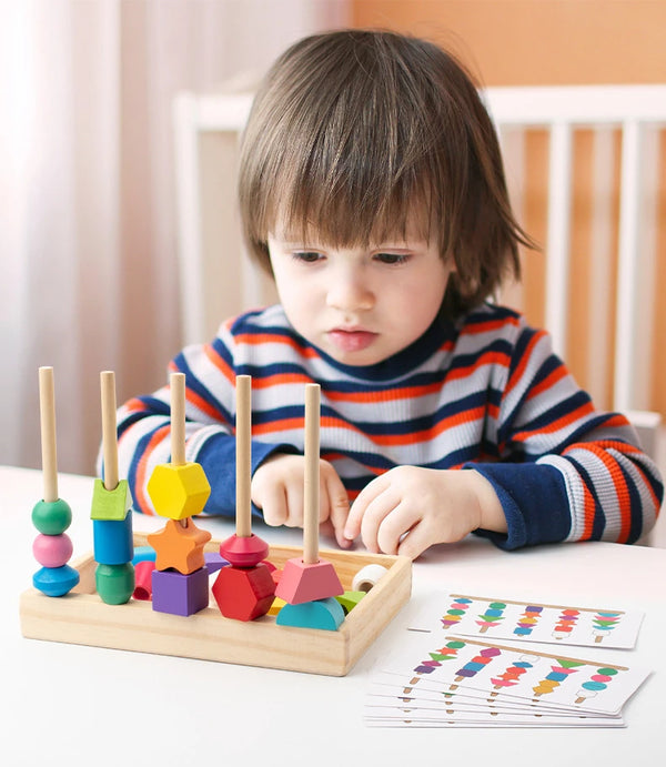 A young child is playing with a wooden shape matching puzzle on a table.