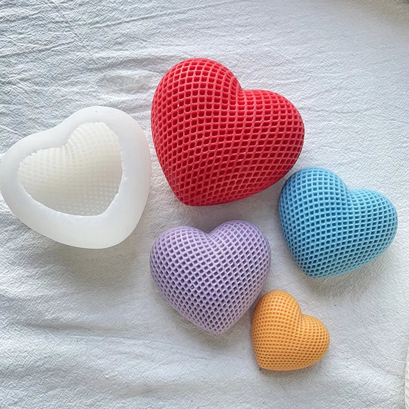 A collection of silicone heart molds in red, white, blue, purple, and orange resting on a white cloth.