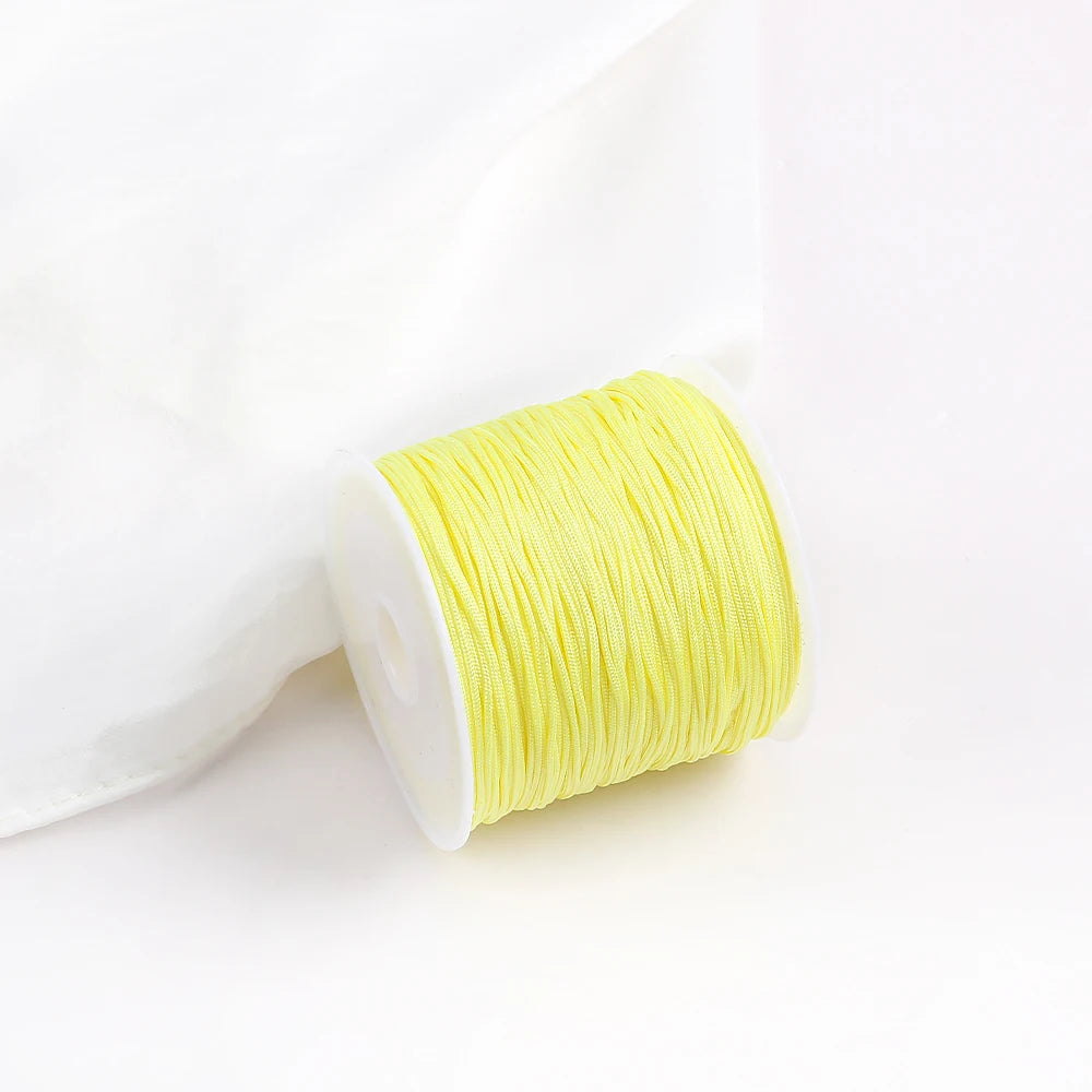 A roll of bright yellow 0.8mm cotton nylon macrame cord for jewelry making and crafts.