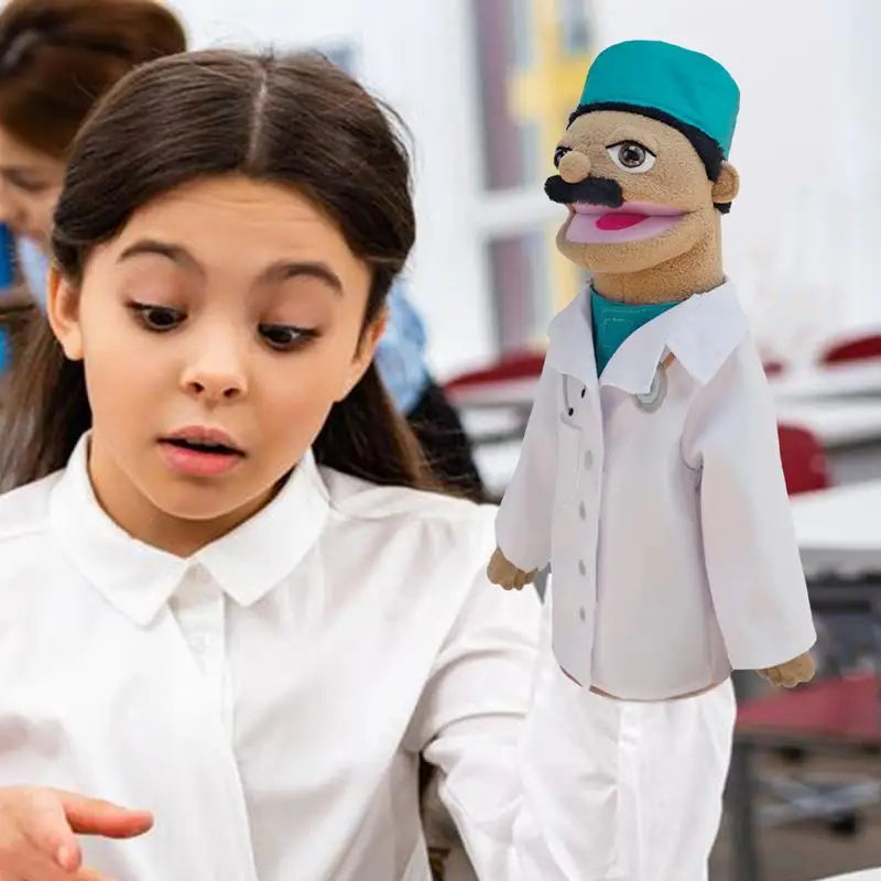 A young girl looks at a soft plush career hand puppet dressed as a doctor.