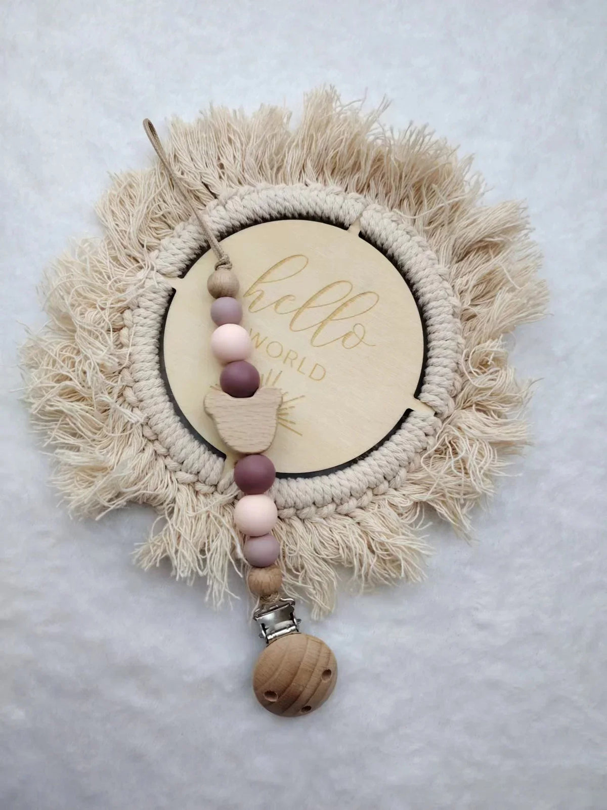 A personalized wooden baby pacifier clip featuring silicone beads attached to a natural fiber wreath.