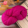 A ball of vibrant magenta yarn used for knitting or weaving, displayed on a wooden surface.