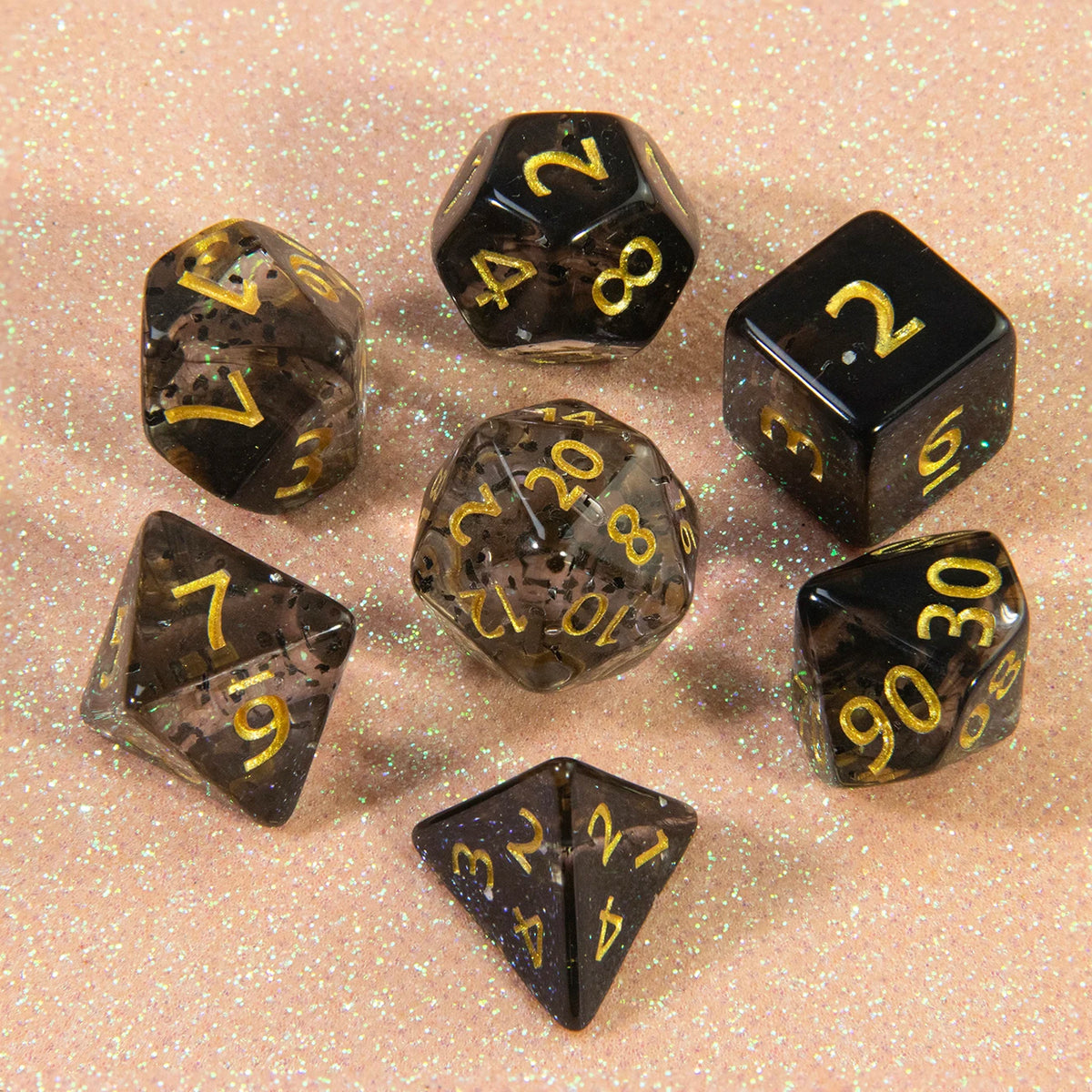 A collection of glitter polyhedral dice including a D4, D6, D8, D10, D12, and D20 set scattered on a light surface.