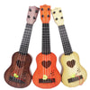 Three wooden ukulele toys in brown orange and yellow with adjustable tuning pegs