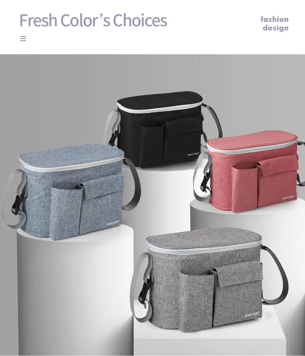 A collection of four fabric stroller organizer bags in shades of gray, black, and pink are displayed on white pedestals.