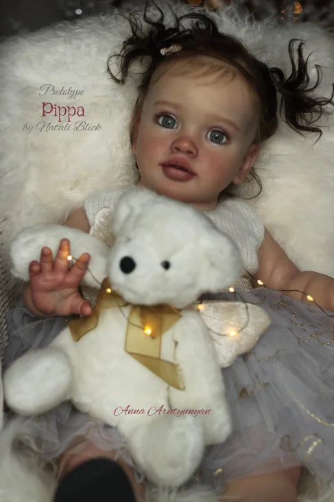 A lifelike reborn baby doll kit featuring a white teddy bear and painted vinyl parts.