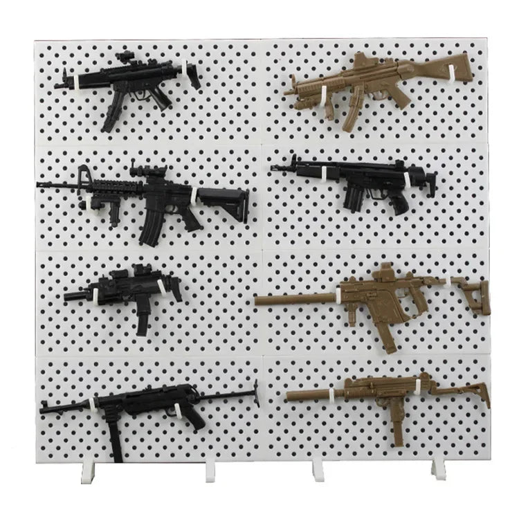 A display of various 1/6 scale military submachine gun model kits on a white grid background.