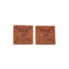 Two brown embossed leather labels with the text Made with Love stamped on them